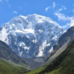a snow covered mountain in the middle of a valley
